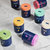 Assorted containers with colorful lids on a marble surface