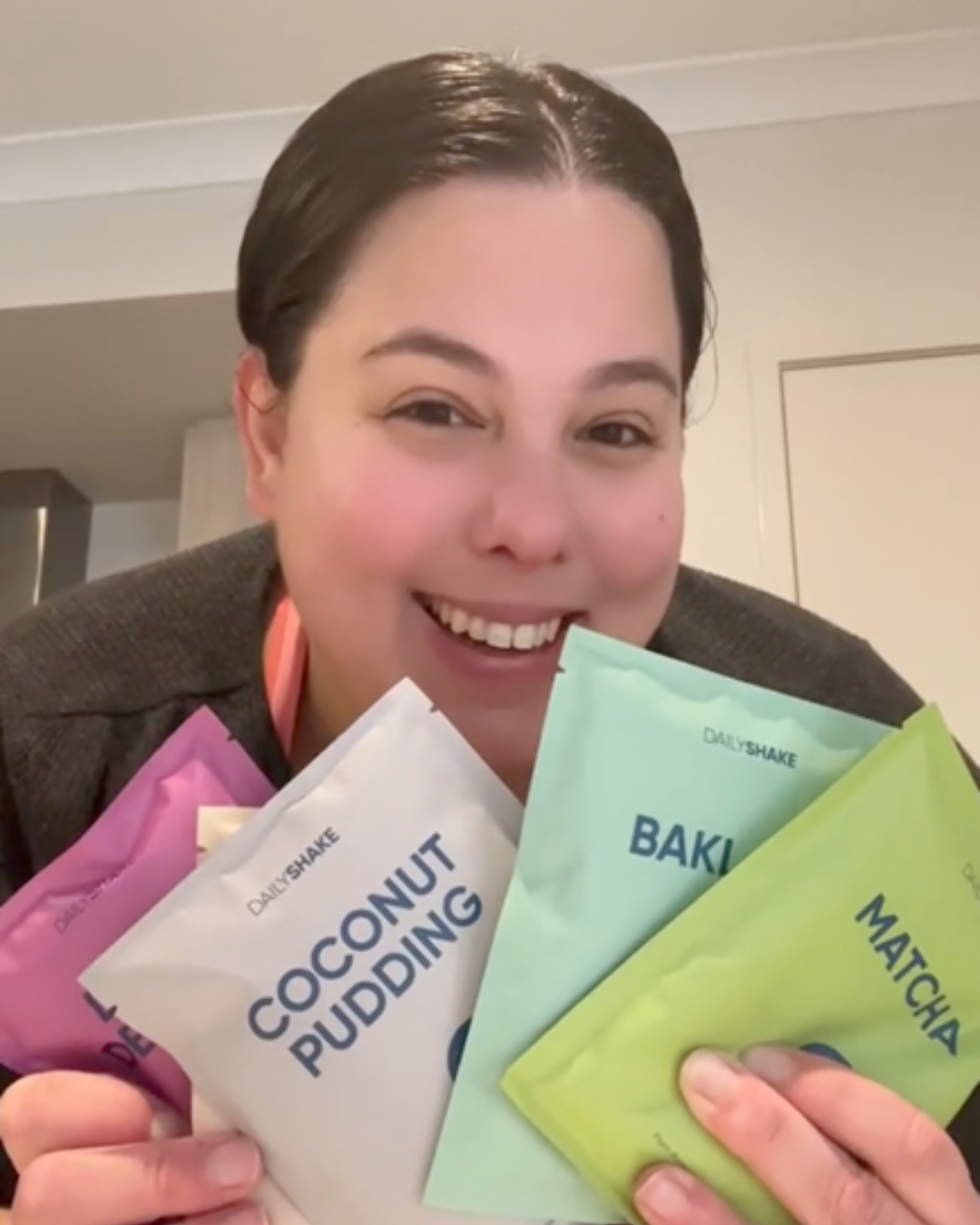 Rose holding Daily Shake sachets for weight loss. Colourfull packaging.