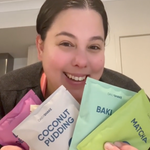 Rose holding Daily Shake sachets for weight loss. Colourfull packaging.